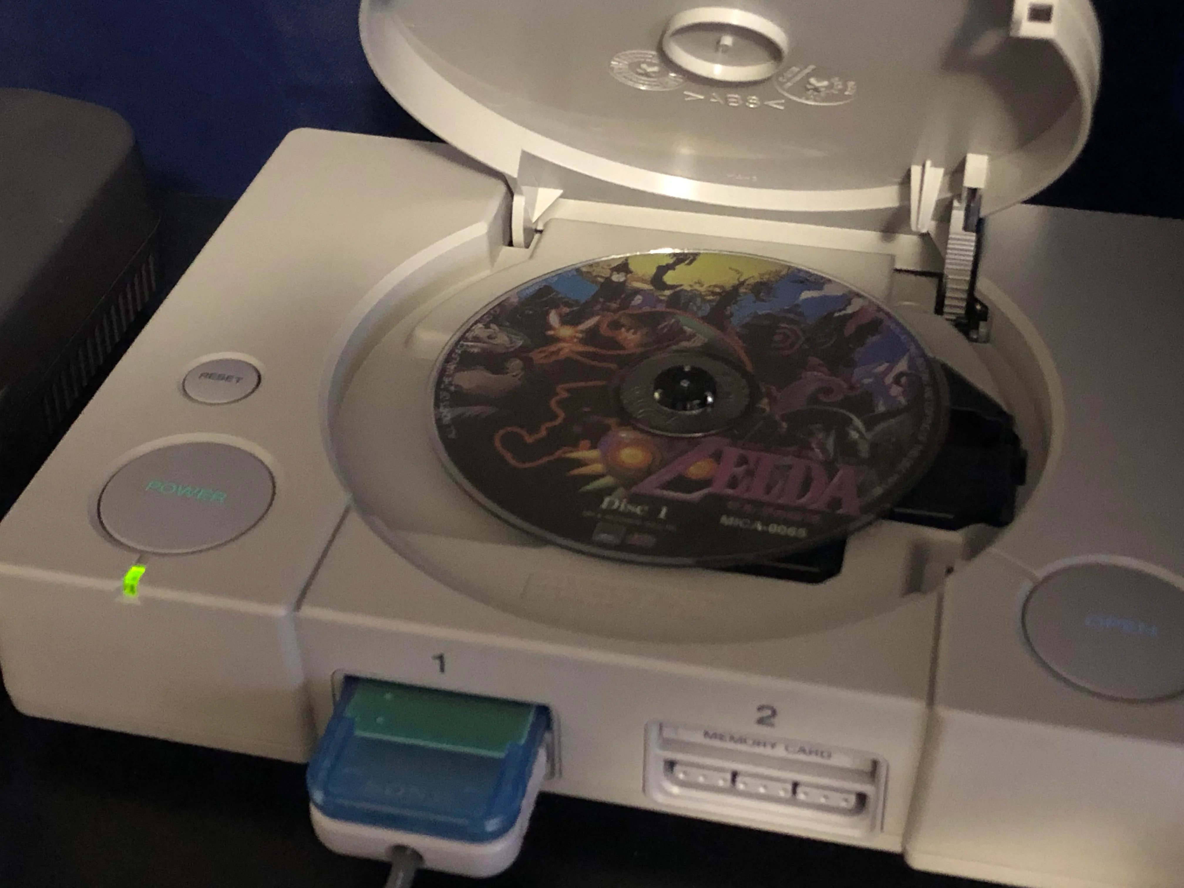 PlayStation avec un CD à l'intérieur, symbole du déclin des piles de sauvegarde.